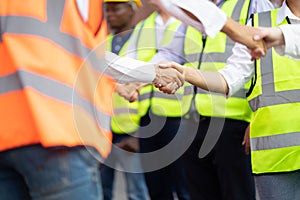 Engineers team shaking hands are congratulated on success of the work. Finishing successful meeting