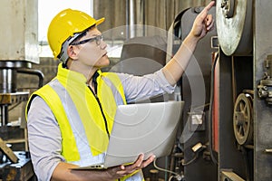 Engineers and technicians are carrying laptops in an industrial factory. Technicians are customizing the operation of industrial photo