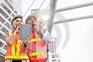 Engineers, technicians Caucasian women and man are looking up Compare with real locations For construction