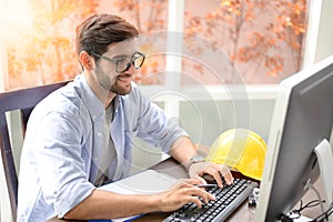 Engineers working within an office using a computer.