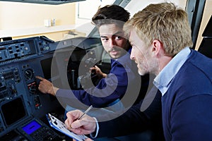 Engineers working in plane cockpit