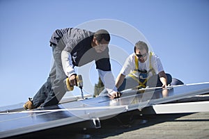 Engineers Working On Solar Panels Against Sky photo