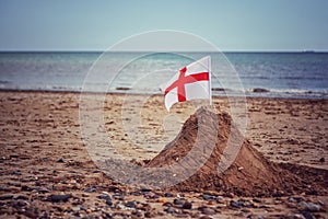 A England flag on a sand castle on a British Beach