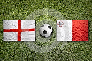 England and Malta flags on soccer field