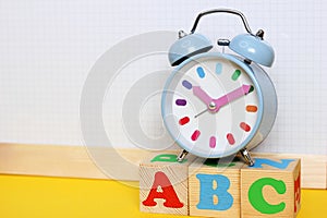 English alphabet. ABC letters on wooden toy blocks. Color funny alarm clock