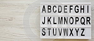 English alphabet on a modern board over white wooden surface, top view. Letters from A to Z. Back to school concept. From above,