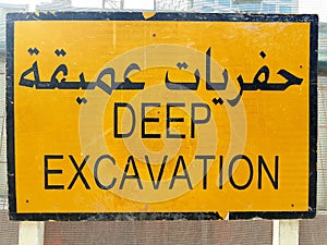 English, Arabic sign located at the entrance of a construction site.