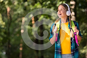 English as second language. Happy child listen to headphones natural outdoors. Language learning courses. Foreign