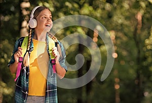 English as second language. Happy child listen to headphones natural outdoors. Language learning courses. Foreign