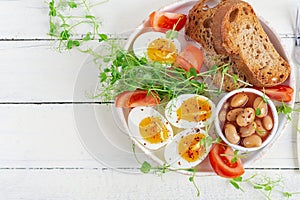 English breakfast. Boiled egg, beans, toast and green herbs.