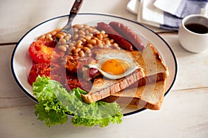 An English breakfast is a breakfast meal that typically includes bacon, sausages, eggs .. photo