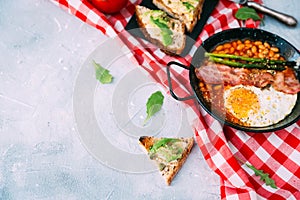 English breakfast concept with avocado toast over blue vintage background.