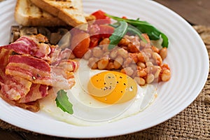 English breakfast - fried egg, beans, tomatoes, mushrooms, bacon