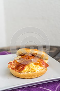English breakfast. Salt muffin with scrambled eggs, bacon and ch