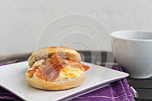 English breakfast. Salt muffin with scrambled eggs, bacon and ch