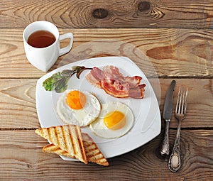 English Breakfast - scrambled eggs, bacon, fried toast and tea