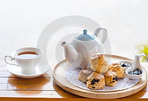 English breakfast and tea break. scones on wooden table with a cup of tea with blur background