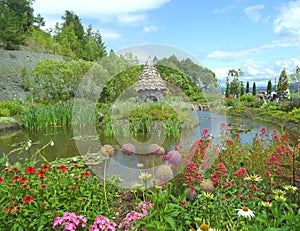 English country style garden with a fairy cottage on the pond