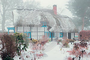 English country village thatched house in winter .