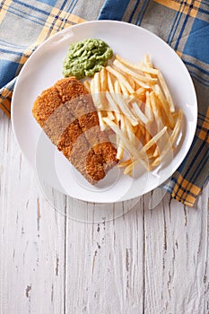 English food: fried fish in batter with chips. vertical top view