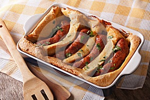 English food: toad in the hole into a baking dish close up. Horizontal