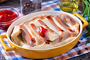 English food: toad in the hole into a baking dish on the table.