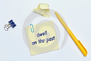 English idiom hand lettering about time - dwell on the past on wooden blocks