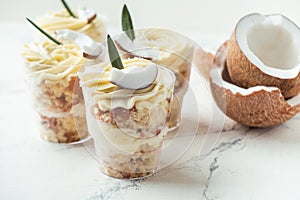 English layered dessert trifle of buscuit dough, custard and whipped cream with fresh coconut pieces