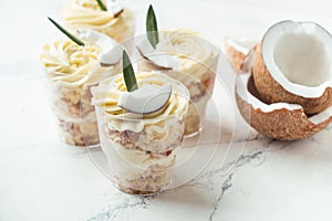 English layered dessert trifle of buscuit dough, custard and whipped cream with fresh coconut pieces photo