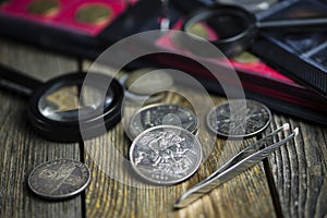 English old coin, magnifier and tweezers, numismatics