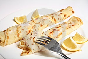 English pancake or crepe, sugar, lemon and fork photo