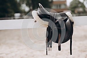 English saddle hanging on a wooden stable door