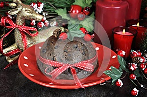 English style Christmas Plum Pudding dessert with traditional festive decorations close up.