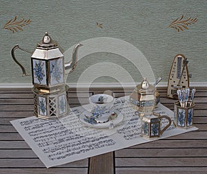 English tea set and metronome for music on a sheet of music