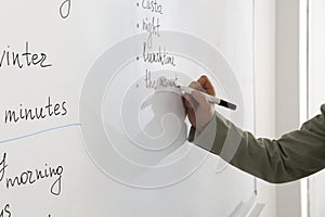 English teacher giving lesson near whiteboard, closeup