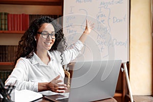 English teacher sitting at desk, explaining lesson to students