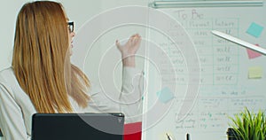 English teacher virtual teaching look at tabletPC give distance lesson. Female school tutor explain online class talking photo
