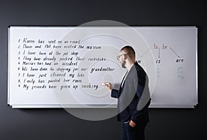 English teacher writing on whiteboard at lesson