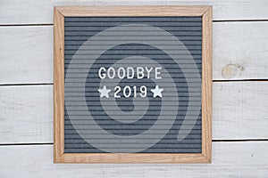 English text goodbye 2019 and two stars on a felt Board in a wooden frame