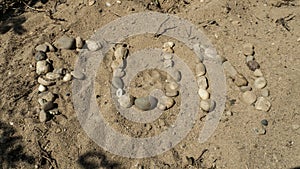 The English word fun with pebble stones laid in sand