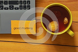 English word laptop good morning and cup of tea on table at home