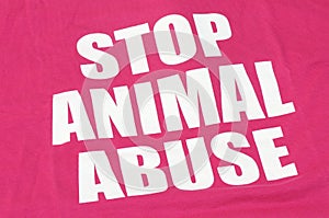 The English words stop animal abuse printed on a red pinkish maroon fabric material