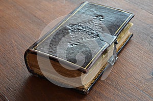 Engraved old book with lock on wood table
