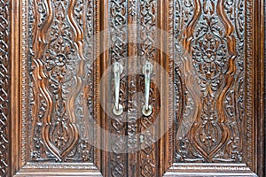 Engraved wooden doors of an old classic cabinet. Antique wooden textures concept.