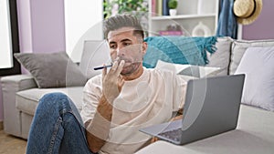 Engrossed young hispanic man, sitting on the living room floor, connecting with the world! listening intently to an intriguing