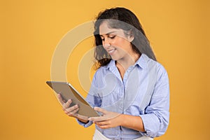 Engrossed young woman with curly hair in a light blue shirt reads content