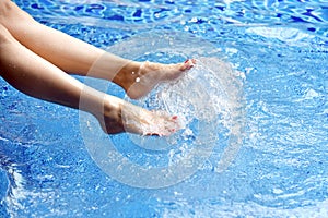 Enjoy beautiful girl relaxing in swimming pool, Legs of woman in water.