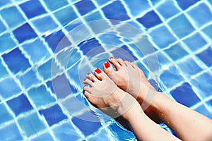 Enjoy beautiful girl relaxing in swimming pool, Legs of woman in water.