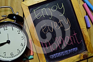 Enjoy Every Moment on phrase colorful handwritten on chalkboard