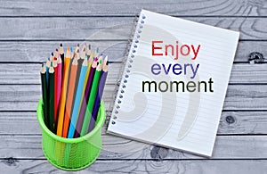 Enjoy every moment words on notebook